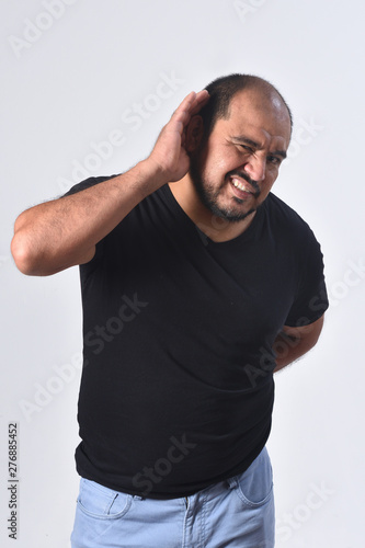 latin american man putting a hand on her ear because she can not hear on white background