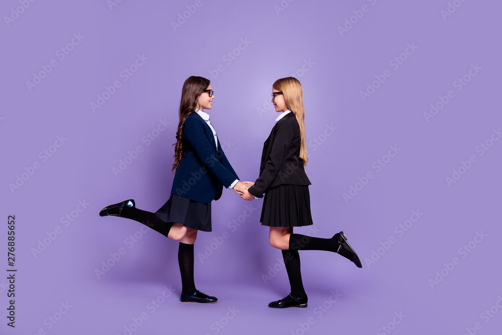 Full length photo profile side of clever intelligent kids trendy stylish isolated over purple background Full length photo profile side of clever intelligent kids trendy stylish isolated over purple background