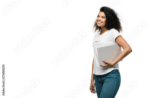 cheerful young african american woman holding laptop isolated on white