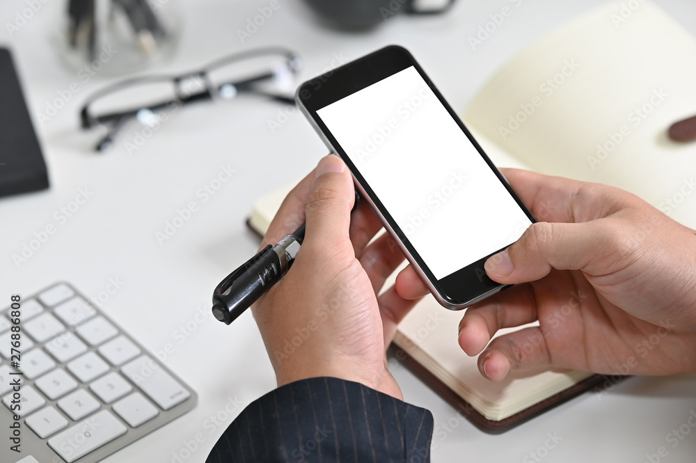 Closeup hands' businessman using mockup smartphone with empty screen.