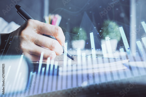 Financial forex charts displayed on woman's hand taking notes background. Concept of research. Double exposure