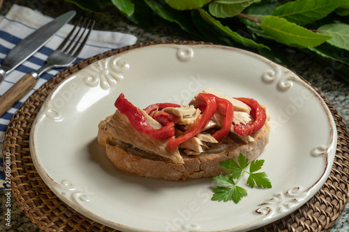 Tasty open sandwich or toast with tuna and red peppers on plate
