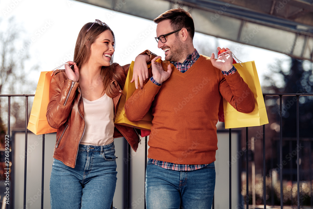 Portrait of a couple with shopping bags in city Portrait of a couple with shopping bags in city