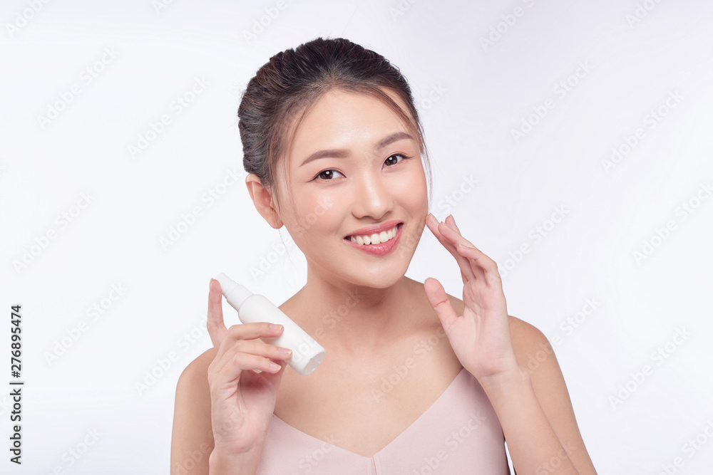 smiling young woman showing skincare products