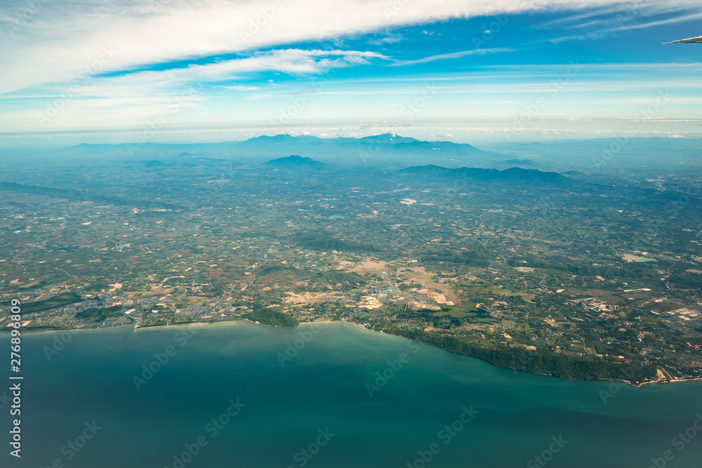 Photo shot from Jet Plane which shot the wide city beside the beach and sea in Middle of Thailand.