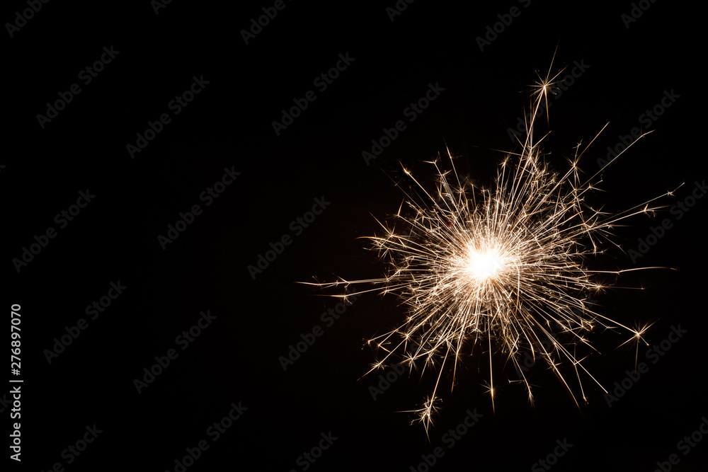 Small new year sparkler on black background.