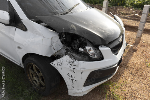 FroFront of white color car damaged and broken by accident park on road. with clipping path car