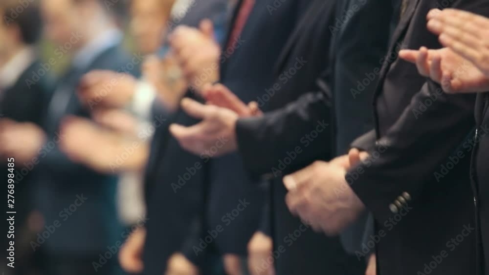Business people standing in the row at the conference - clapping their hands - applause