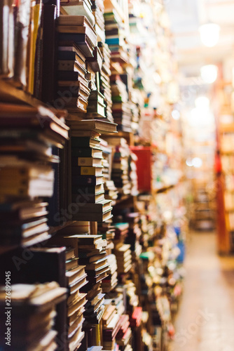 selective focus of vintage books on wooden shelves in library