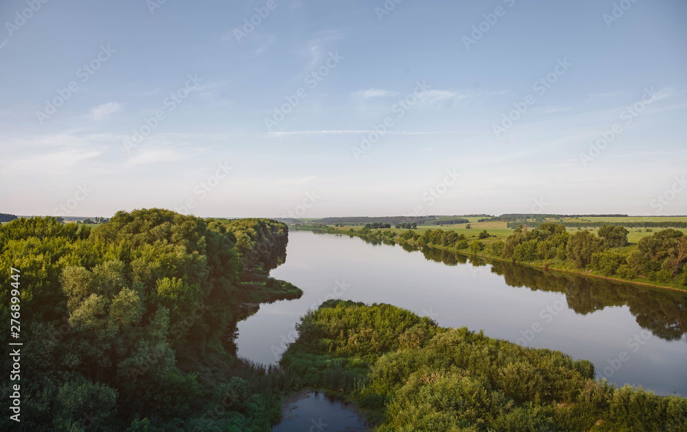 Beautiful natural scenery of river in tropical green forest with mountains in background, aerial view drone shot