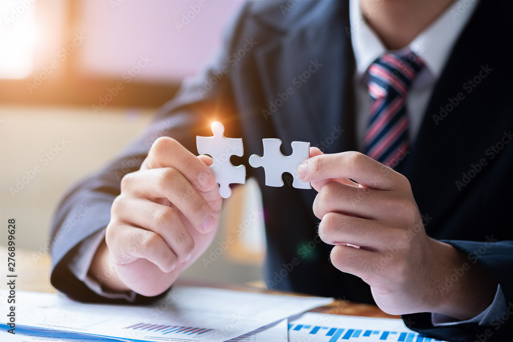 Hands connecting jigsaw puzzle. Business solutions, success and strategy concept. Close up photo with selective focus. Hands connecting jigsaw puzzle. Business solutions, success and strategy concept. Close up photo with selective focus.