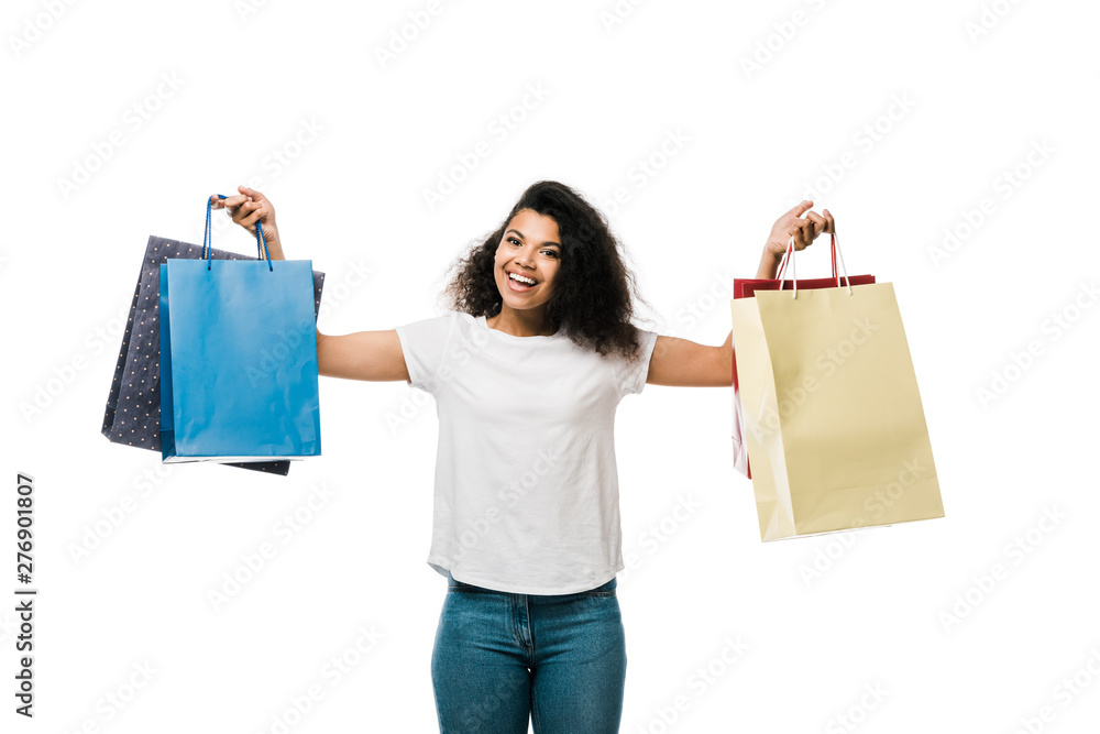 happy african american girl holding shopping bags while standing isolated on white happy african american girl holding shopping bags while standing isolated on white
