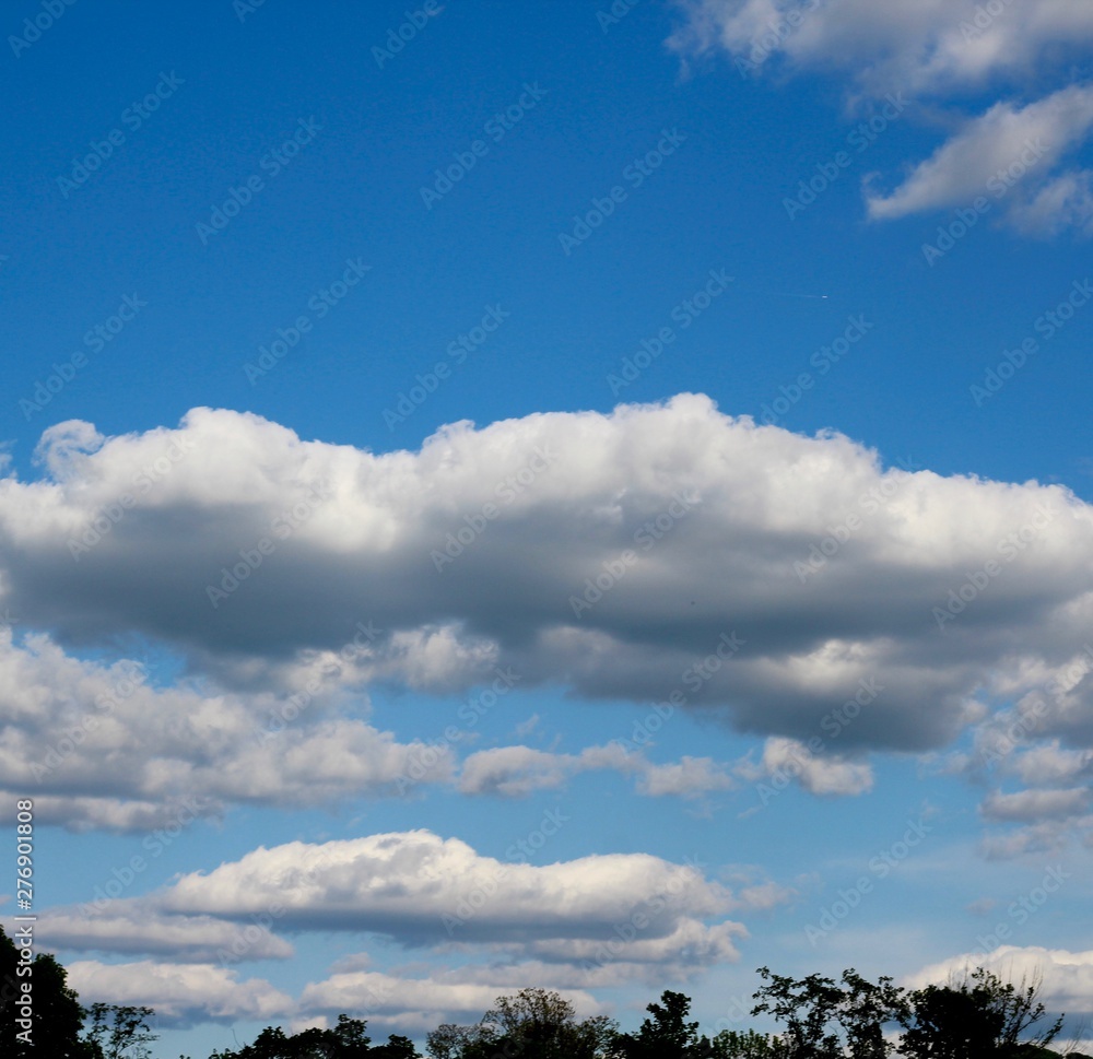 The fluffy clouds in the bright blue sky. The fluffy clouds in the bright blue sky.