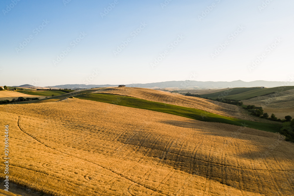 Valle di Orciano Pisano con balle di fieno e campi di grano immensi.