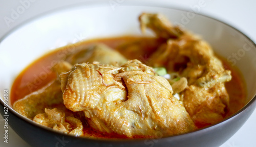 Indonesian gulai ayam or Indonesian chicken curry in a bowl on white background.