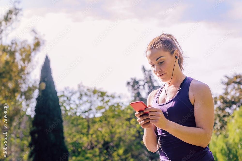 woman checking her phone app before running woman checking her phone app before running