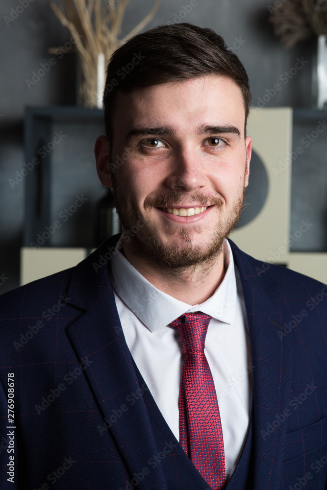 Close up portrait of an elegant man in a three-piece suit stands in interior studio Close up portrait of an elegant man in a three-piece suit stands in interior studio