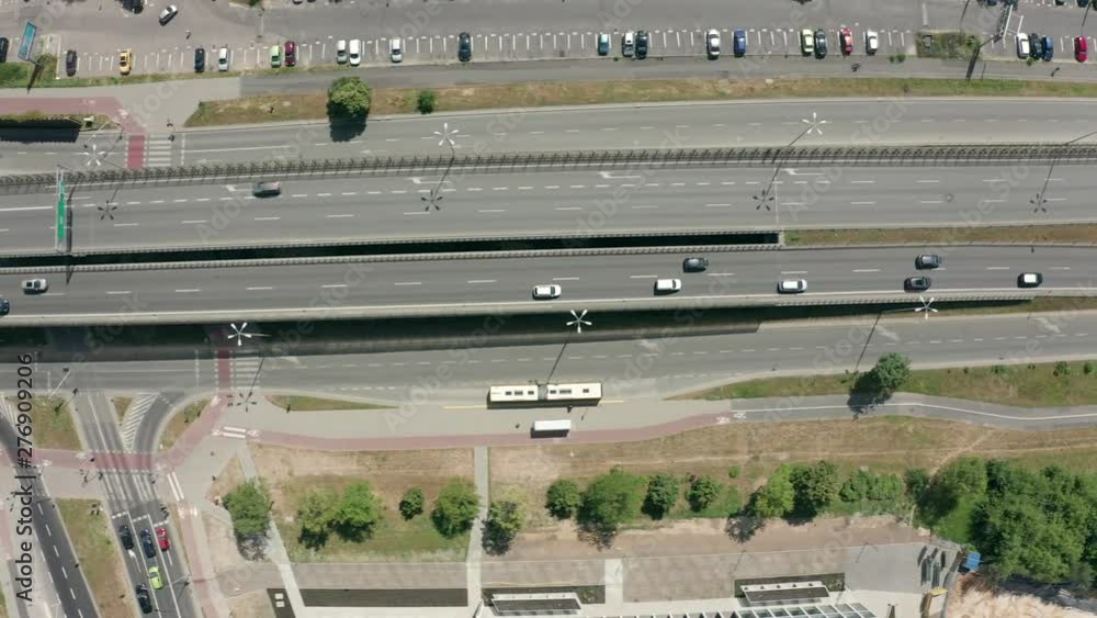 Aerial view of the busy highway of the city of Warsaw. Traffic passing by a highway. Top view of highway and overpass in city on a sunny day. Shot on Drone 4K. Aerial view of the busy highway of the city of Warsaw. Traffic passing by a highway. Top view of highway and overpass in city on a sunny day. Shot on Drone 4K.