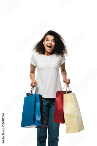 excited african american girl holding shopping bags isolated on white