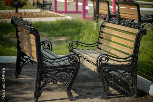 Two benches stand opposite each other. Bench in the park with a trash can. © Алексей Р