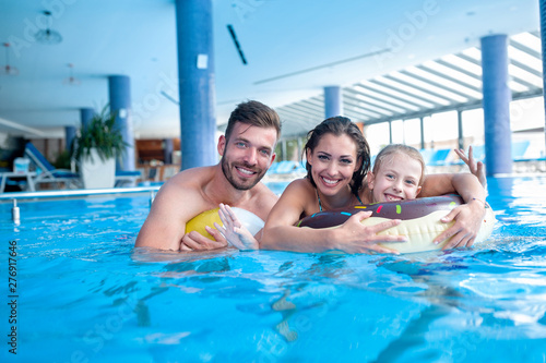 Happy parents with their daughter having fun in the swimming pool © didesign