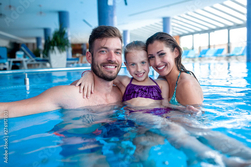 Family of three having fun in the swimming pool © didesign
