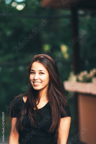 Portrait of beautiful happy long hair asian girl in black t-shirt on street