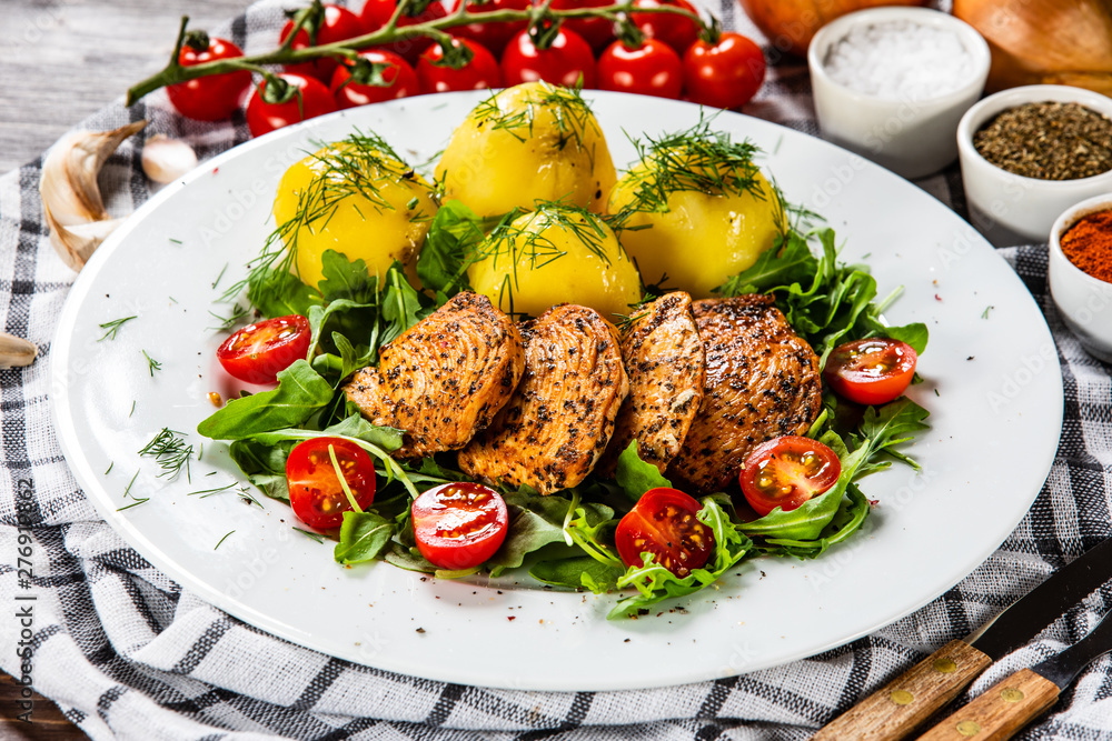Grilled chicken fillet and vegetables on white plate Grilled chicken fillet and vegetables on white plate
