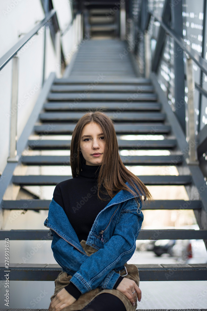Portrait of a young caucasian lady with freckles on stairs of a club Portrait of a young caucasian lady with freckles on stairs of a club