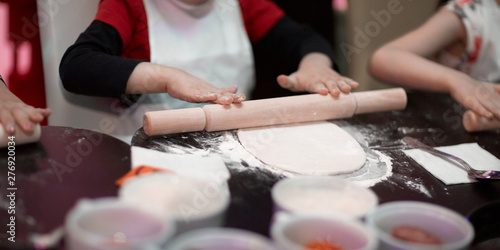 close up.a professional chef teaches a little boy to roll out the dough.