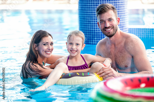 Happy couple enjoying their time in the pool with their daughter © didesign