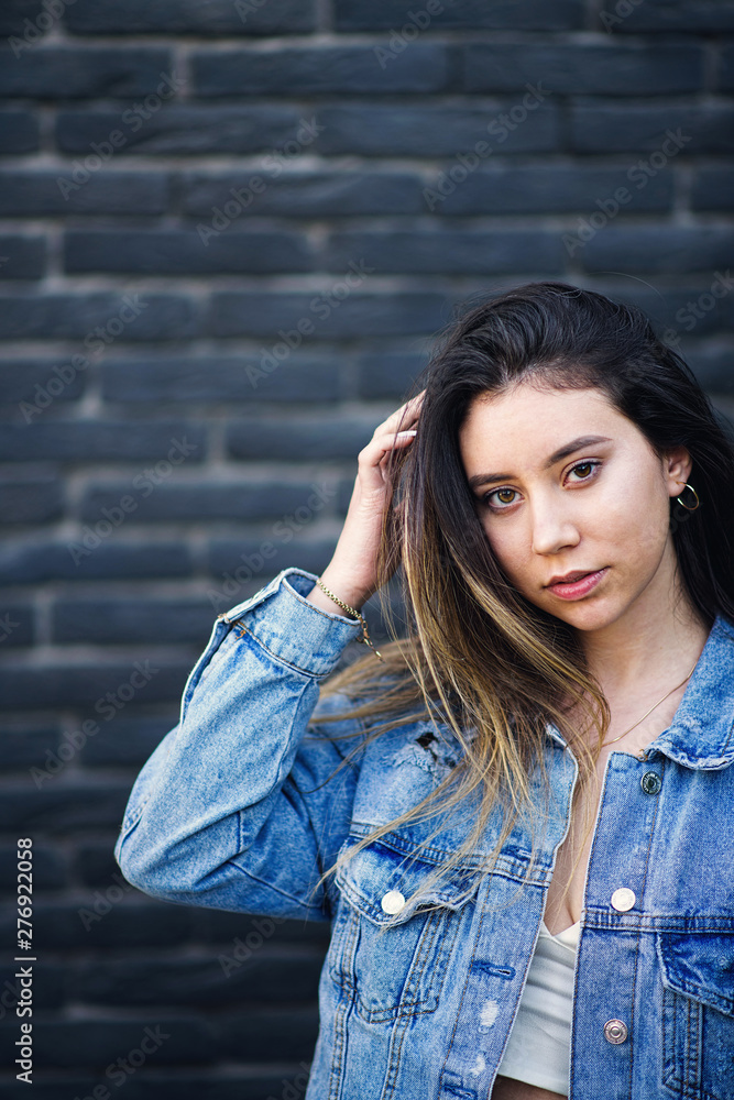 Young caucasian girl with strike hair posing on black brick wall Young caucasian girl with strike hair posing on black brick wall