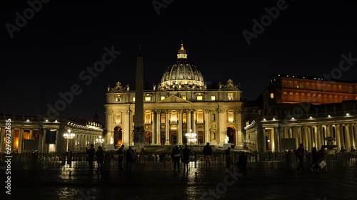 Illuminated Saint Peter cathedral by night, with people tourists taking pictures and star on sky,rome italy 