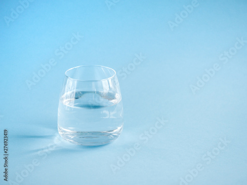 a glass of plain water on a blue background