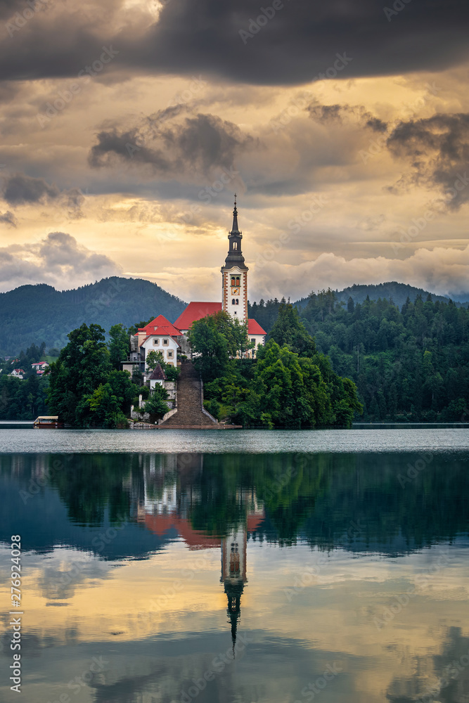 Bled, Slovenia - Golden sunrise at Lake Bled (Blejsko Jezero) with the Pilgrimage Church of the Assumption of Maria on a small island and Julian Alps at background at summer time