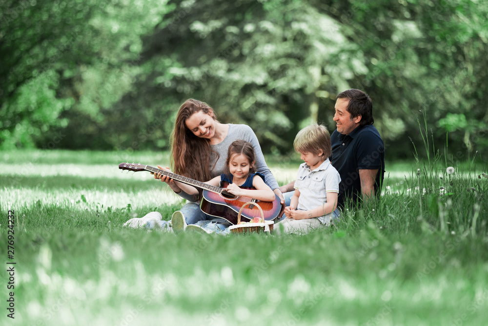 Riendly, cheerful family having a picnic in the park Riendly, cheerful family having a picnic in the park