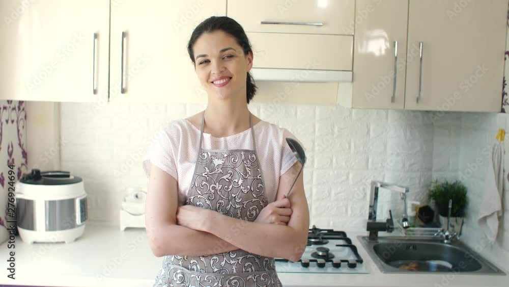 Portrait of smiling young housewife in modern kitchen Portrait of smiling young housewife in modern kitchen