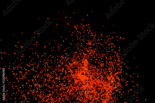Orange dust particles explosioon on black background.