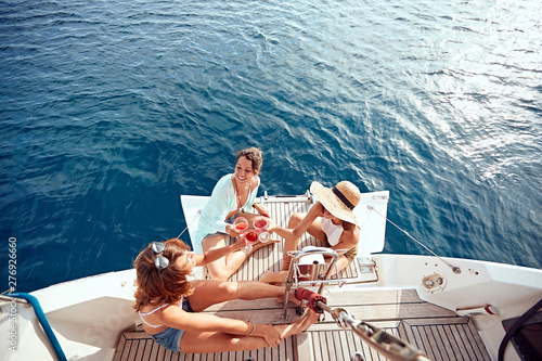 friend’s girl having party on sailing boat and drinking wine top view. © luckybusiness