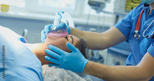Several doctors surrounding patient on operation table during t