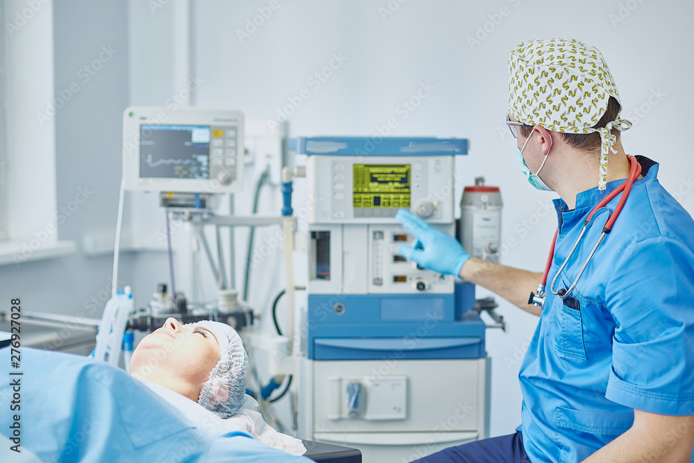 Several doctors surrounding patient on operation table during t Several doctors surrounding patient on operation table during t