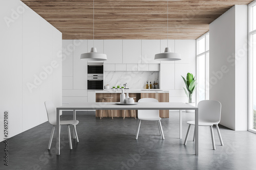 White kitchen interior with bar and table