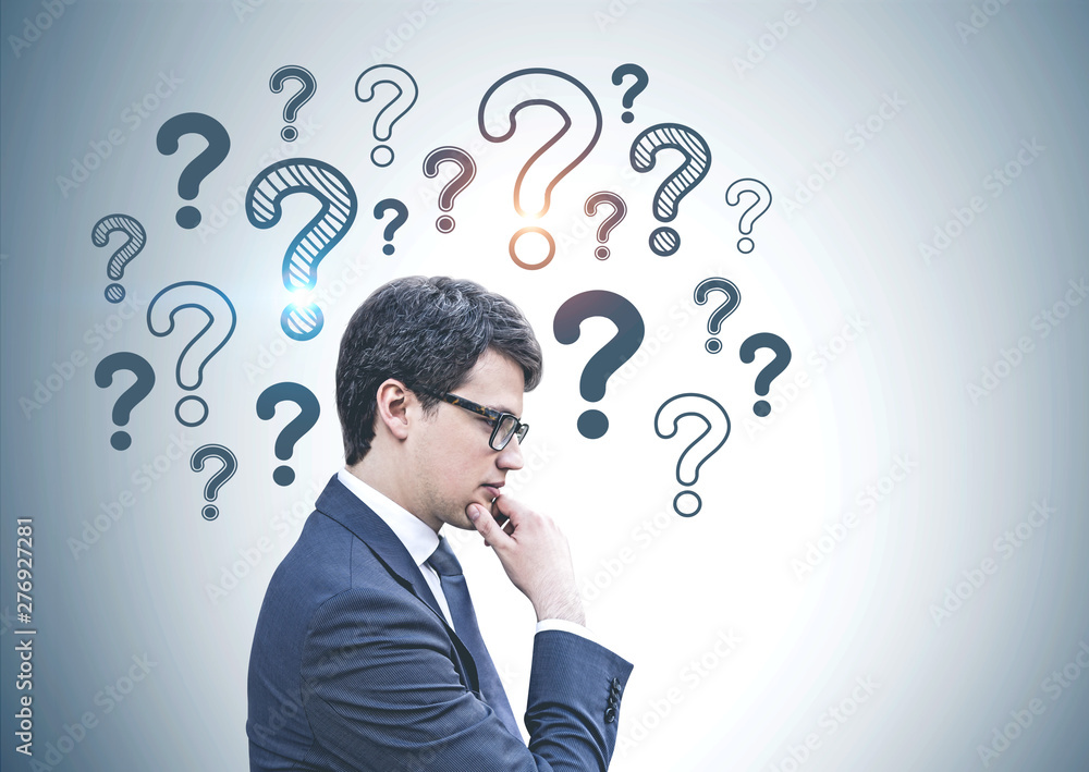 Pensive businessman in glasses, question marks Pensive businessman in glasses, question marks