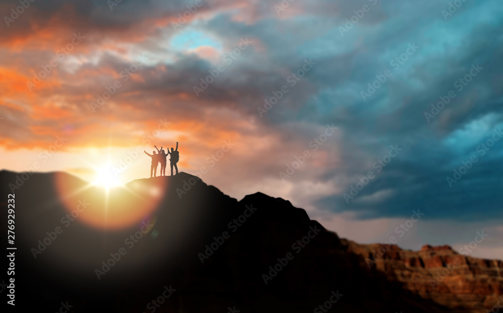 travel, tourism and people concept - group of travelers on mountain top over sunset in grand canyon national park background