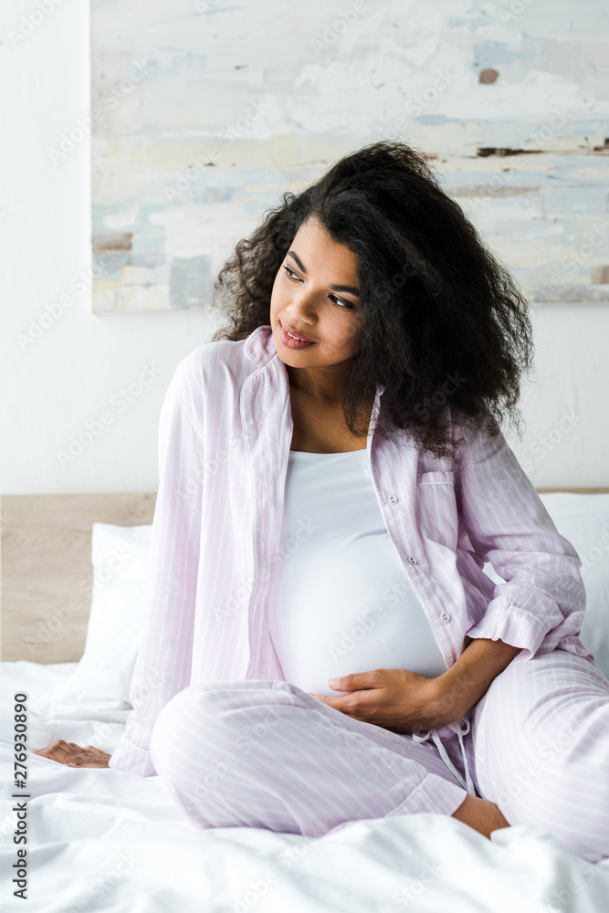 beautiful pregnant african american woman touching belly on bed beautiful pregnant african american woman touching belly on bed