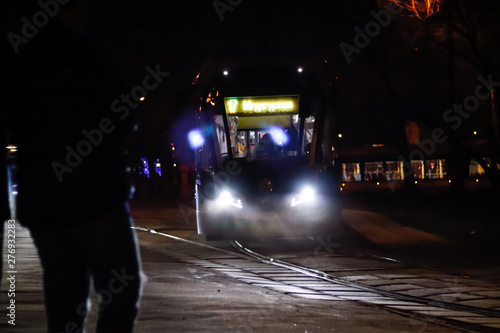 the tram arrives at the stop at night in Moscow
