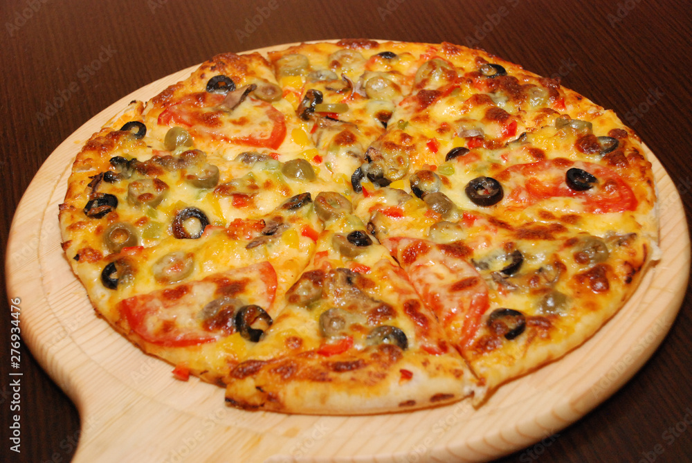 Pizza on the thin dough with cheese and olives
