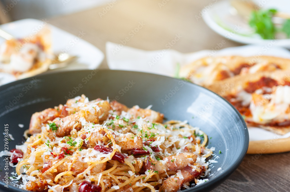 Italian food set, spicy spaghetti bacon with roasted chilli and crispy shrimp on woodent table in restaurant. Italian food set, spicy spaghetti bacon with roasted chilli and crispy shrimp on woodent table in restaurant.