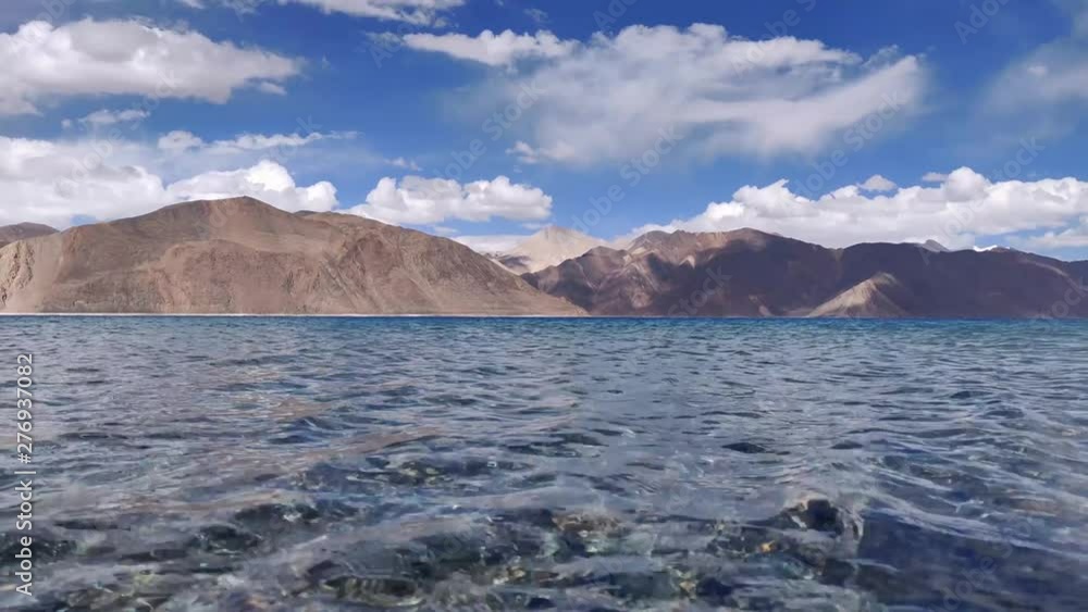 Close up of Crystal clear water of the Pangong Tso lake (world's highest saltwater lake at 14,000ft) with dry mountains behind it. (4k, 60fps, High definition, 1080p) Close up of Crystal clear water of the Pangong Tso lake (world's highest saltwater lake at 14,000ft) with dry mountains behind it. (4k, 60fps, High definition, 1080p)