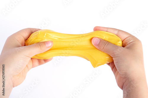 Foto Children's hands stretch homemade goo and yellow slime
